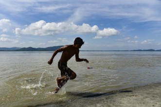 Boys jump in the Brahmaputra river during an a hot summer day in Guwahati, india on July 11, 2022