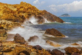 Rugged rocks and foaming spray on Topinetti beach, near Rio Marina, Elba Island, Tuscan Archipelago