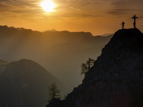 Mountaineers at the summit cross of the Kleiner Jenner at sunset, Reiteralpe in the background,