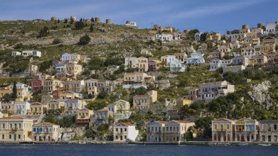 Colourful harbour village on a hill with traditional Greek architecture, Symi Town, Symi,