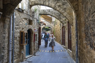 Narrow alley with archway in the old town, surrounded by stone walls, Rhodes Old Town, Rhodes,