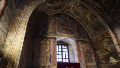 Richly decorated church interior with icons and an altar table covered with purple fabric, Thari