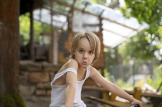 Boy, blonde, 6 years, in vest, gesture, grimace, in the garden, summer, Stuttgart,