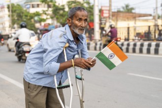 A differently abled person holds a tricolour as he take part in a rally, in soliderity with the