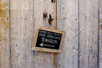 Wooden door with small slate plaque in the old town of Santanyi, Majorca, Balearic Islands, Spain,