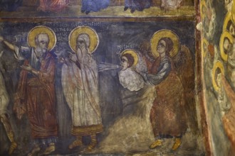 Holy figures in a fresco, one blessing a child on a cloud, winged and symbolically depicted, Easter