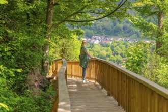 Woman enjoying the view of the village while walking along the wooden path, Panorama Holzsteg,