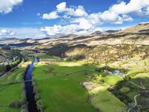 Farms and Mountains over River Dochart and Road A85 from a drone, Perthshire, Scotland, UK