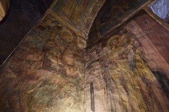 Detailed frescoes in a church depicting saints with halos and architectural elements, Thari