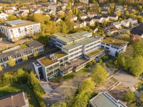 Urban area with modern architecture, surrounded by autumnal landscape from a bird's eye view,