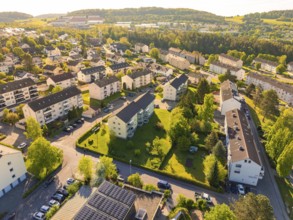 Aerial view of a residential area with numerous houses and green landscape on a sunny day, Calw,