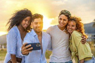 Four cheerful young friends enjoying a sunset beach selfie, capturing joyful moments filled with
