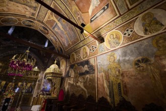 Church interior with frescoes and icons, richly decorated murals with biblical scenes, Thari