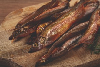 Cold smoked capelin, on a wooden chopping board, no people