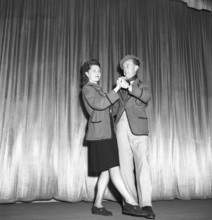 Dancing in the 1940s. A couple in full figure pictured when dancing, holding each other moving to