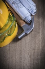 Claw hammer safety glasses rolled blueprints and building helmet