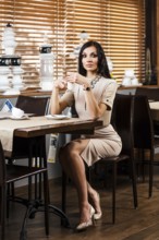 Beautiful young woman sitting in the cafe alone