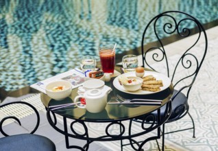 Gourmet continental breakfast table set at luxury hotel poolside