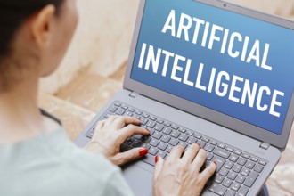 In this photo illustration, the Artificial Intelligence (AI) text is displayed on a laptop screen