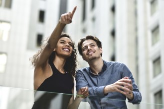 Happy international couple have a conversation in city. Mixed-race woman and caucasian man