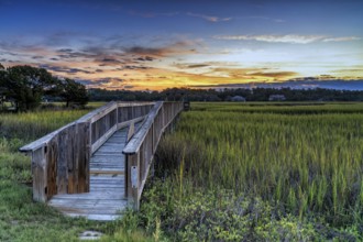 Long wooden dock on the inlet at Pawleys Island in South Carolina at usnset