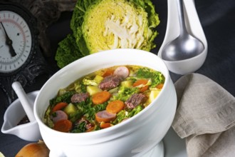 Delicious savoy cabbage soup in a white vase