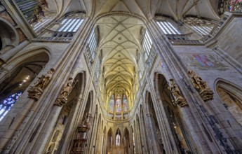 Majestic Gothic Saint Vitus cathedral interior with high ceilings, arches, and light casting