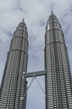 Two striking twin towers under a cloudy sky, modern and majestic, kuala lumpur, malaysia