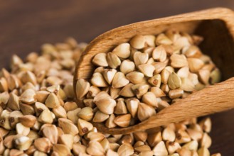 Buckwheat with a spoon on a wooden board background