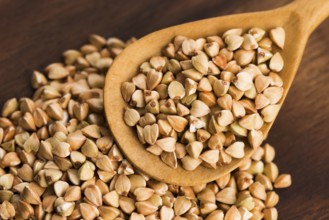Buckwheat with a spoon on a wooden boards background