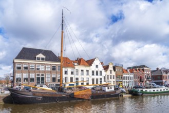 ZWOLLE, NETHERLANDS, MARCH 14, 2021: Old boats and barges in front of some nice gabled houses in