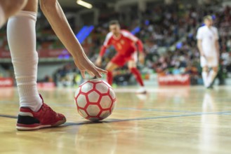 Close up of the futsal ball in the corner and player's leg