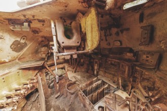 Dilapidated interior of a tank with rusty metal, full of old, rotting parts and structures, M41