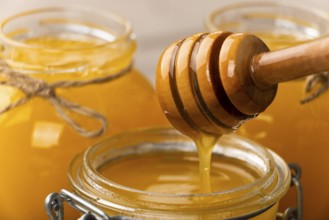 Honey on wooden honey-dipper closeup food background