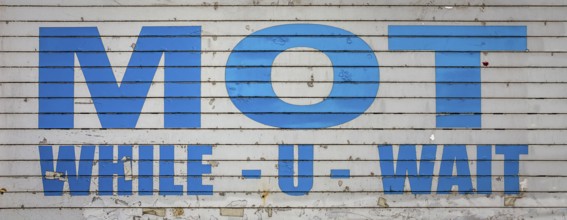A Grungy Old MOT While You Wait Sign In The UK