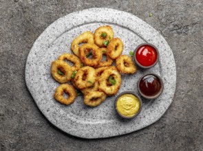 Food, Food, Fried squids rings on gray stone plate with sauces. Gray concrete background