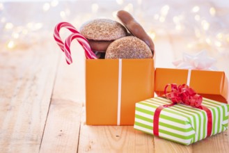 Ton of colorful gifts, one opened full with gingerbread and Xmas candies, laid on a wooden