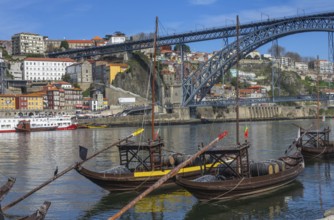 Traditional boats on Douro river with bridge in Porto, Portugal, Europe