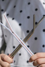 Woman holding Reusable Metal and plastic drinking Straws. Female Hand on reusable collapsible