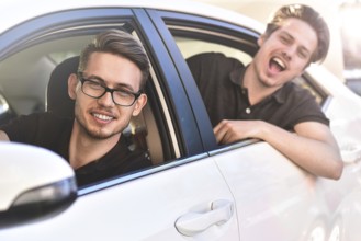 Enjoying travel. Beautiful young couple sitting on the front passenger seats and smiling while