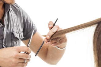 Professional hairdresser with long hair model, in front of white background
