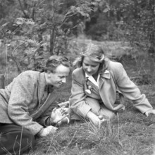 Couple in the nature. A young couple pictured sitting on the ground looking at a mushroom. Sweden