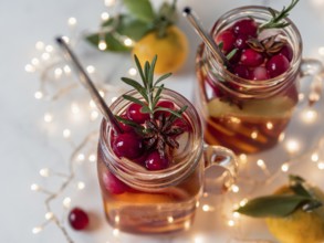 Winter sangria in mason jars with metal straws on christmas holiday background. Decorated fruit