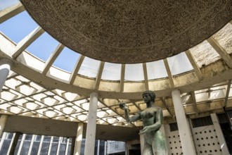 Sculpture Devojka under the ornate remains of a dome in Belgrade's dilapidated modern architecture