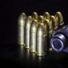Black gun and bullets on a black background