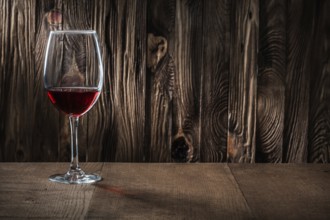 Copyspace view wineglass with red wine on vintage wooden background