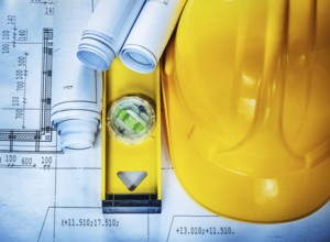 Hard hat construction level drawings on blueprint