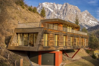 Alpine scenery with a mountain peak in background and in foreground an interesting modern building,