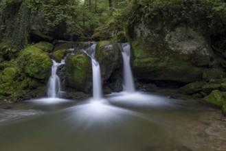 Cascade shooting pond, waterfall under small pedestrian bridge, Mullerthal Trail, Waldbillig,