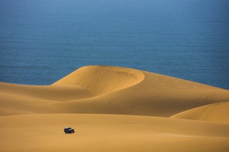 Dangerous and gorgeous jeep - safari through the huge sand dunes on the ocean shore. Atlantic coast